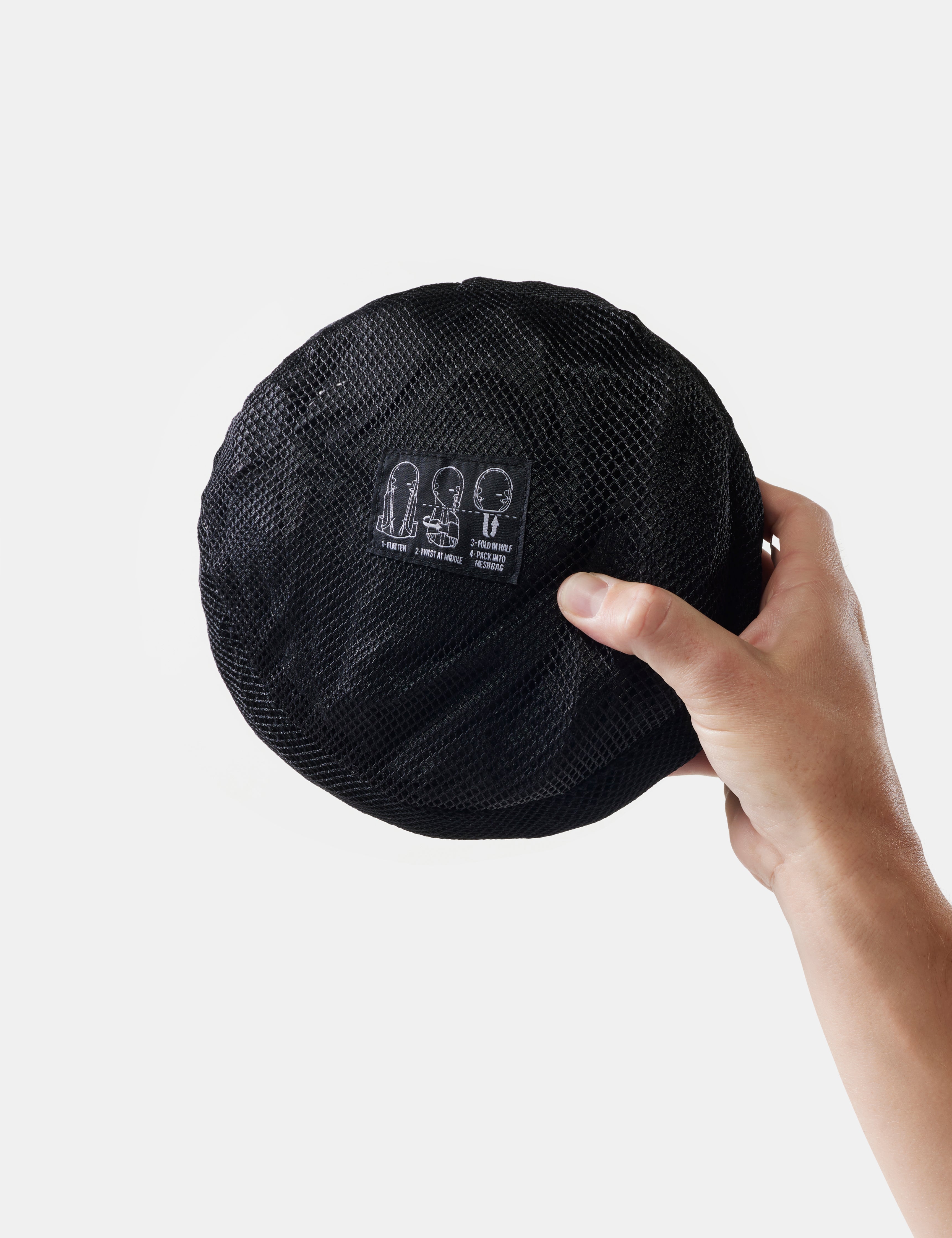 packed up backpack held by a hand against a white background