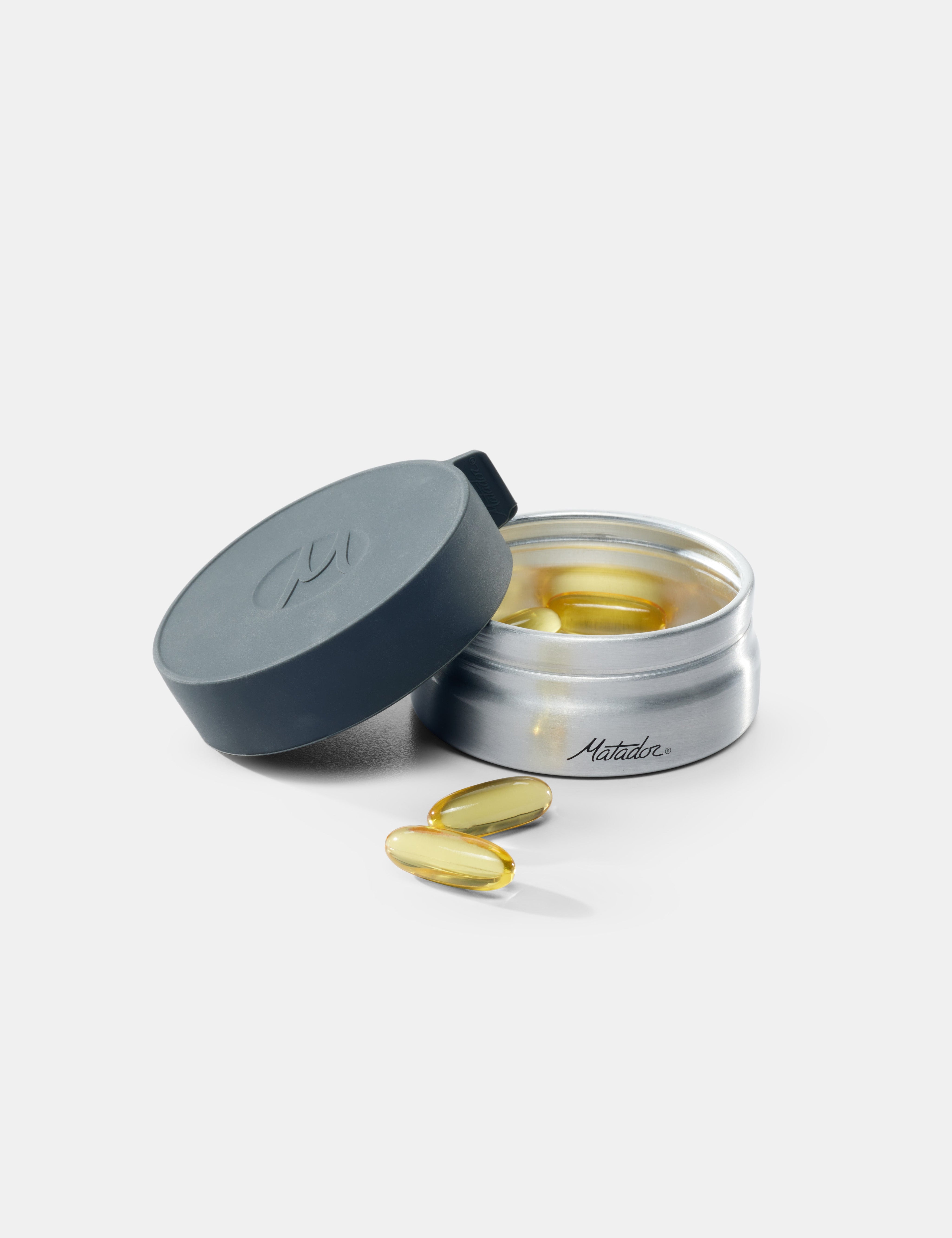 Open container of supplements with pills on a white background
