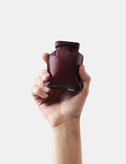 Hand holding garnet soap bar case on white background