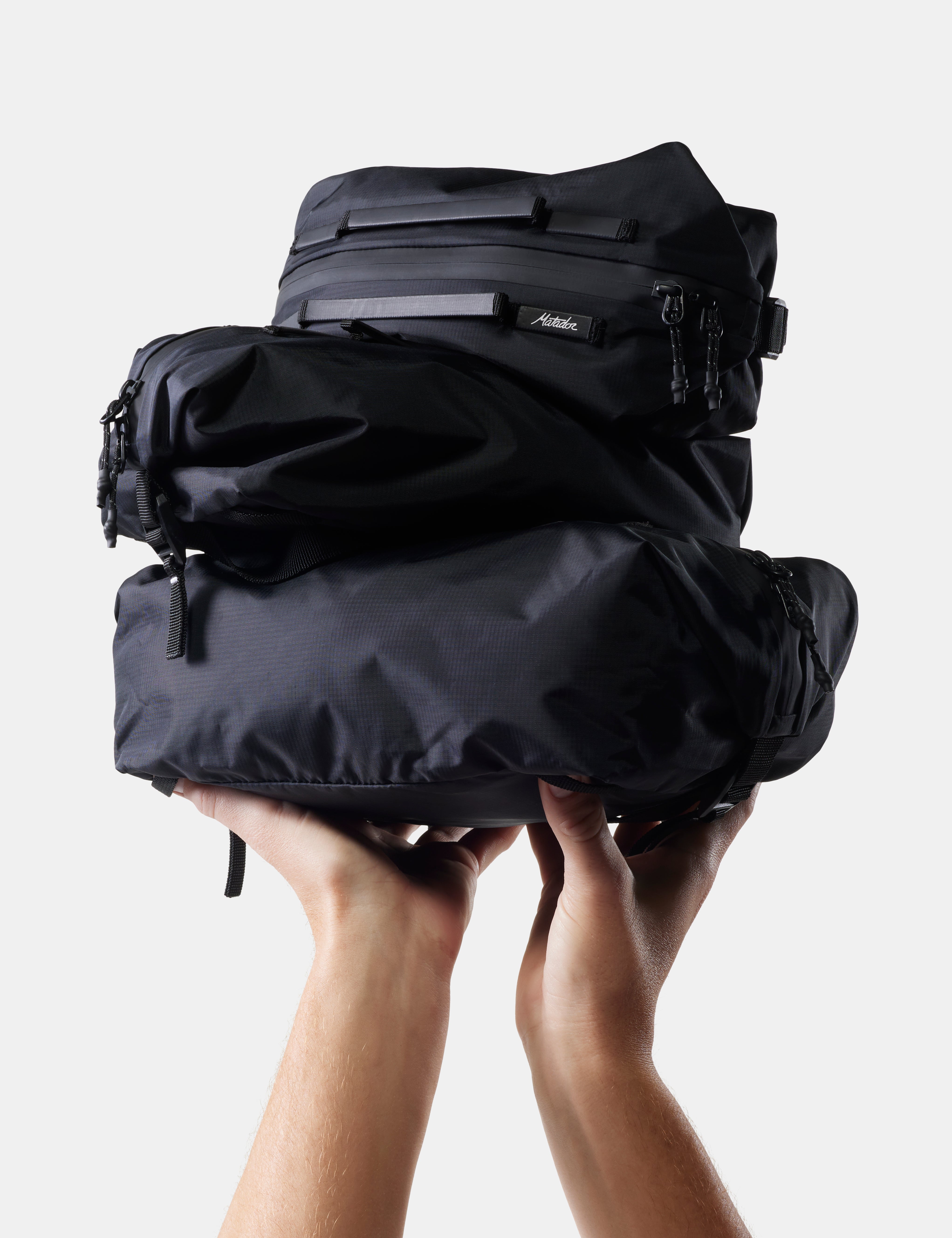 3 black gear cubes being held up on white background