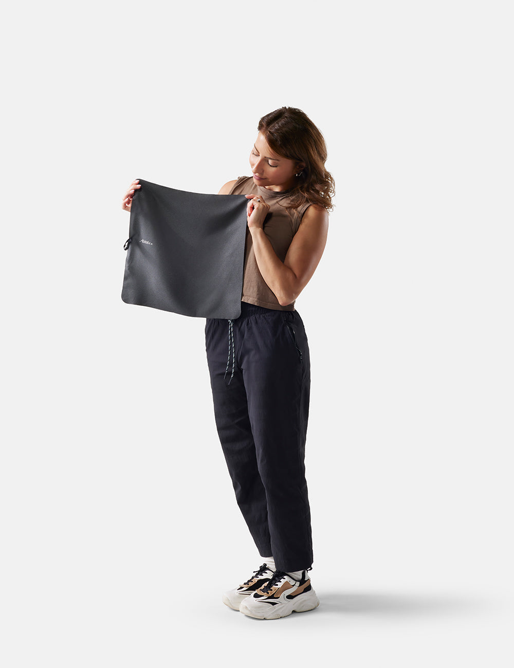 Woman holding small towel against a white background