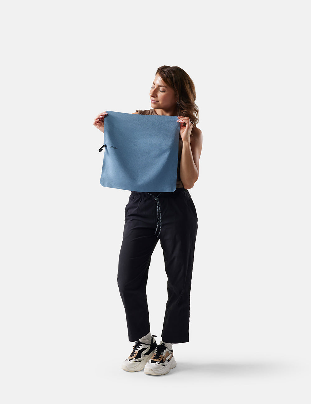 Woman holding slate towel against a white background