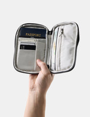 hand holding open travel wallet with passport and credit cards