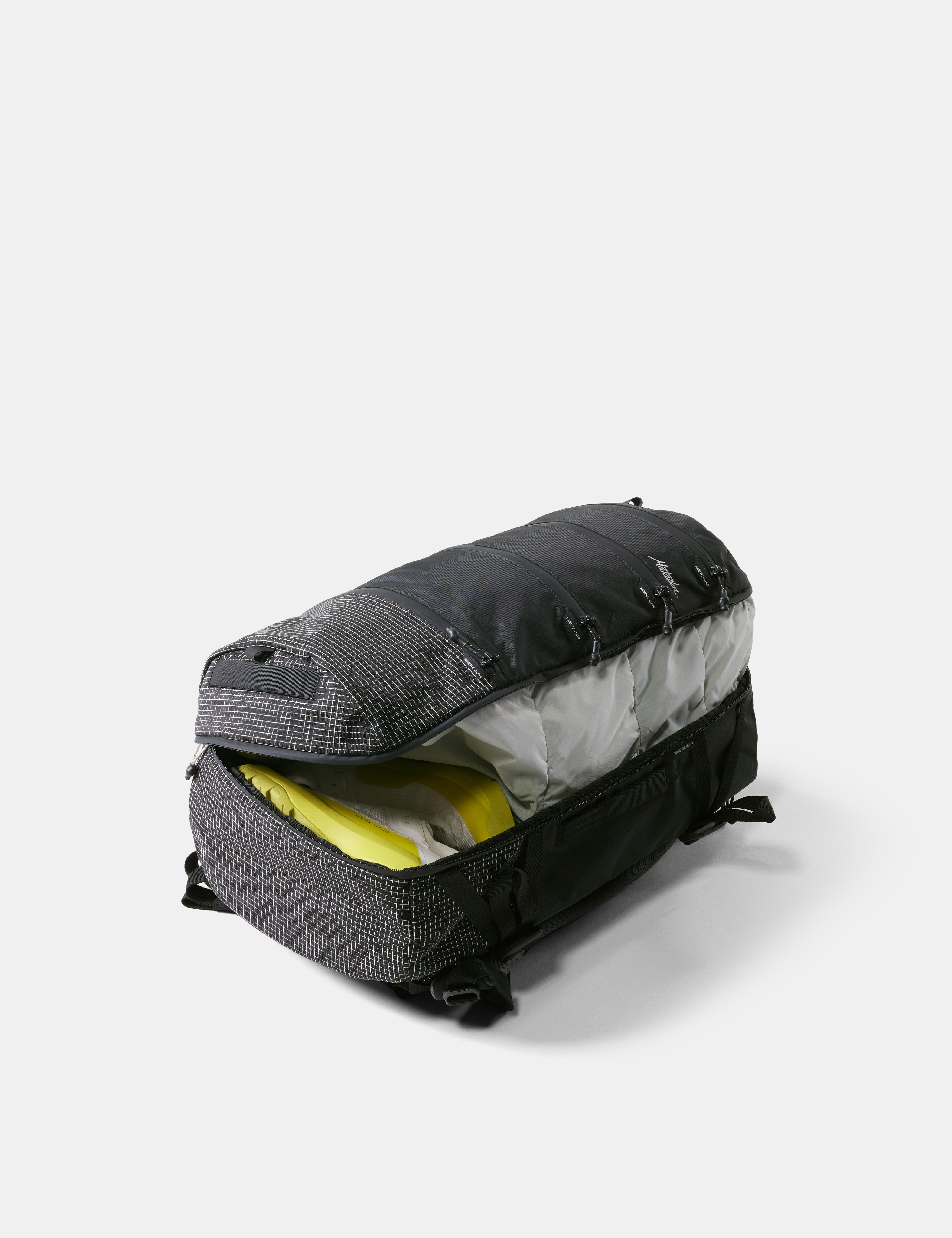 Black duffel bag with yellow interior contents on a white background
